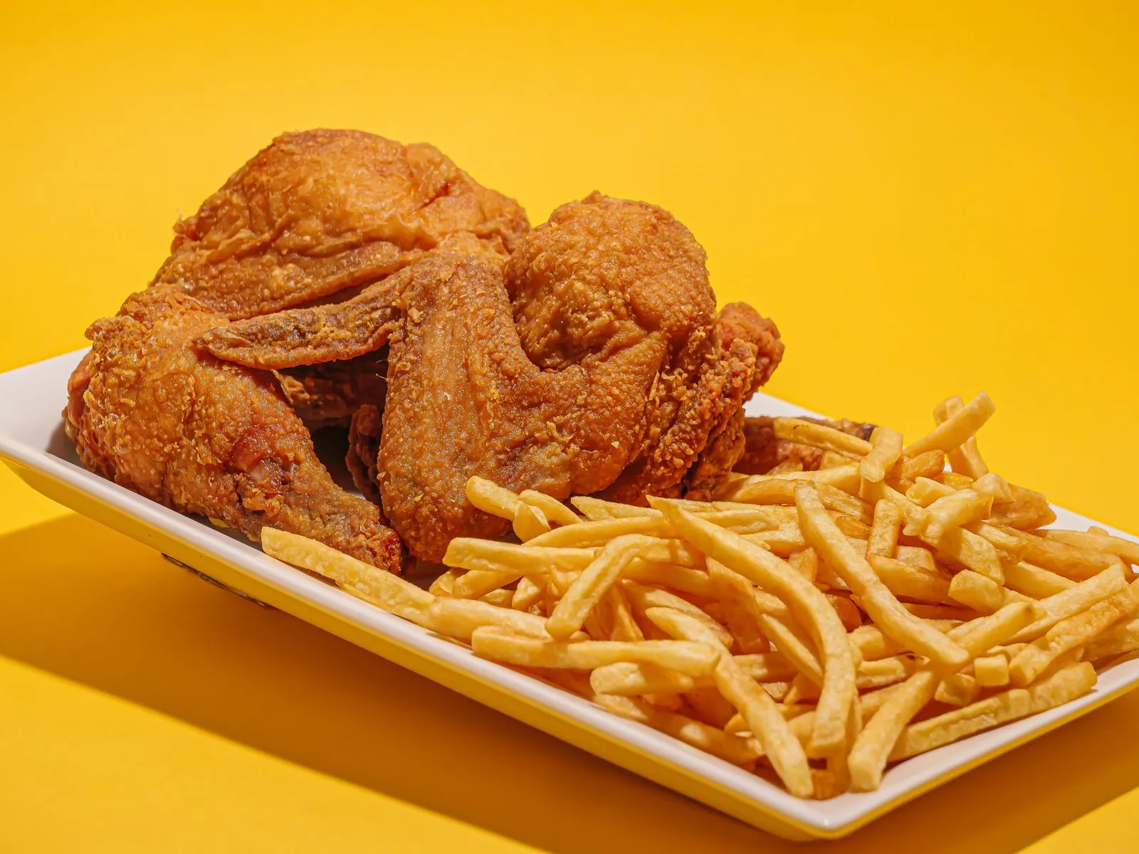 Representative golden fried chicken with a pile of french fries.