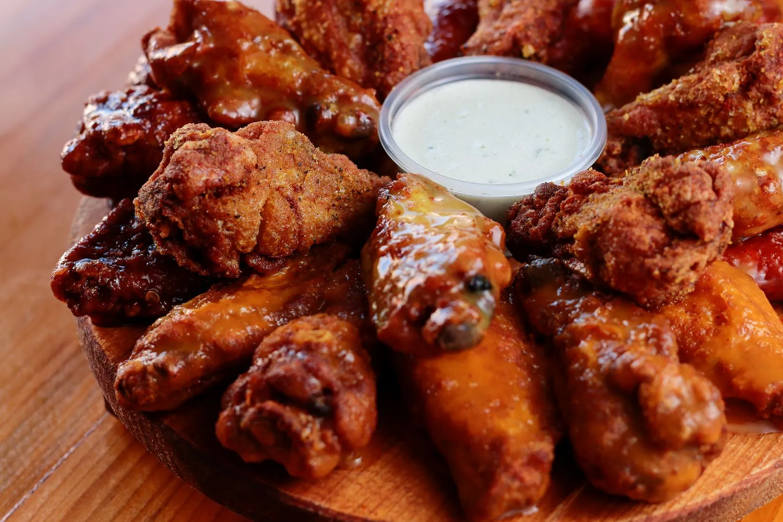 A platter of crisp party wings with dipping sauce.
